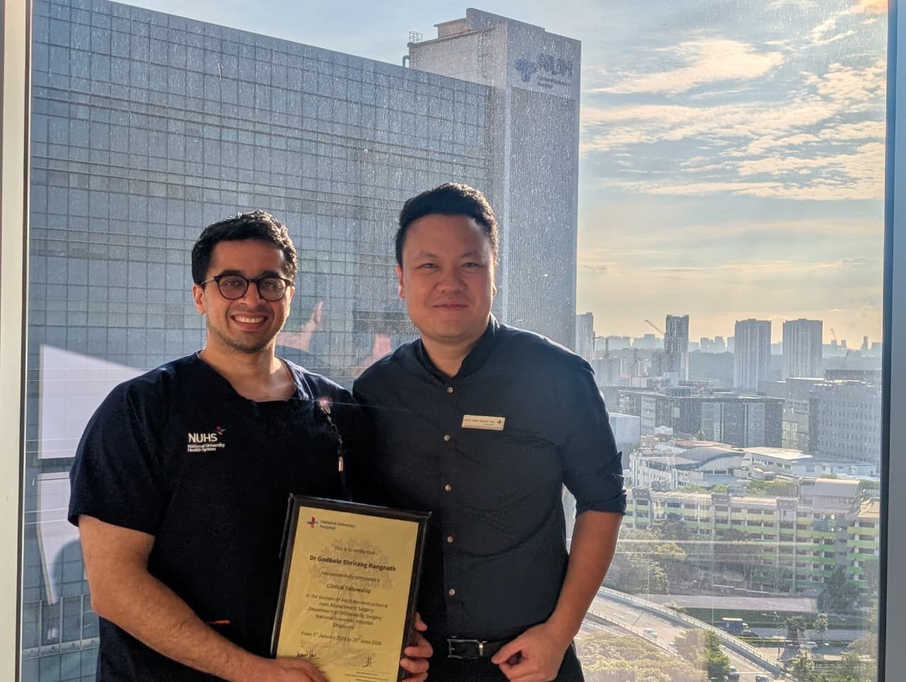 Dr. Godbole receiving his NUH fellowship completion certificate with Dr. Barry Tan